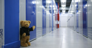 self-storage-bear. Плюшевый коричневый мишка в чёрном кафтане
